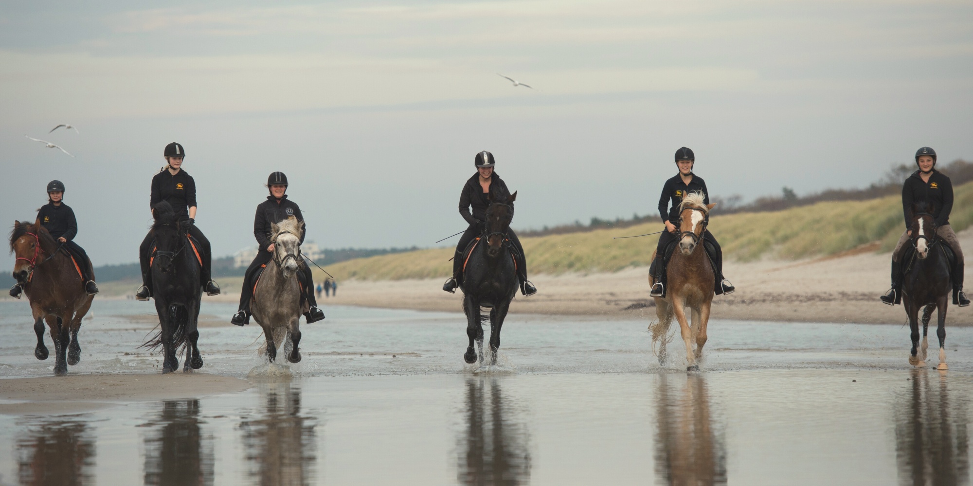 Reiter reiten entlang Ostseeküste